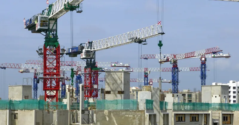 Bouwplaats met gebouw in aanbouw en enkele hijskranen