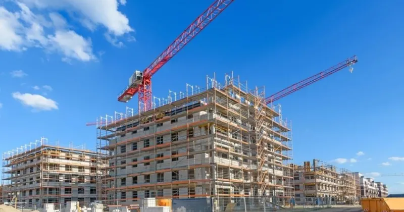Bouwplaats met gebouw in aanbouw en enkele hijskranen