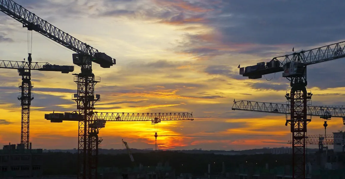 Zonsondergang met enkele hijskranen op de achtergrond